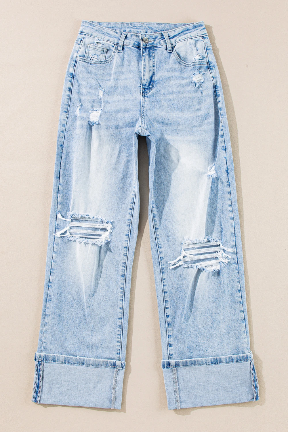 Flat lay of light wash distressed high-rise wide leg jeans showing full front and cuff detail