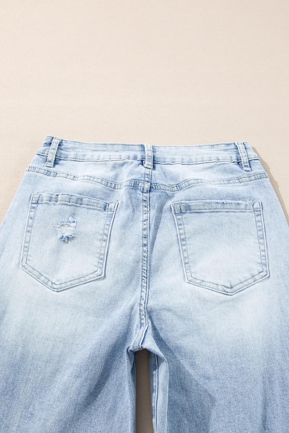 Back view of light wash distressed high-rise wide leg jeans showing back pockets